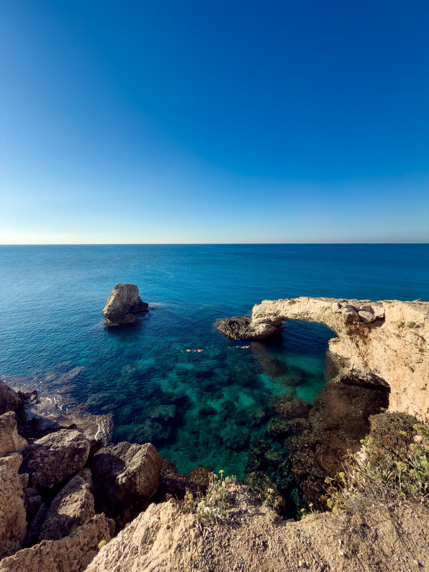 Une arche de rocher au-dessus d’une eau turquoise et transparente